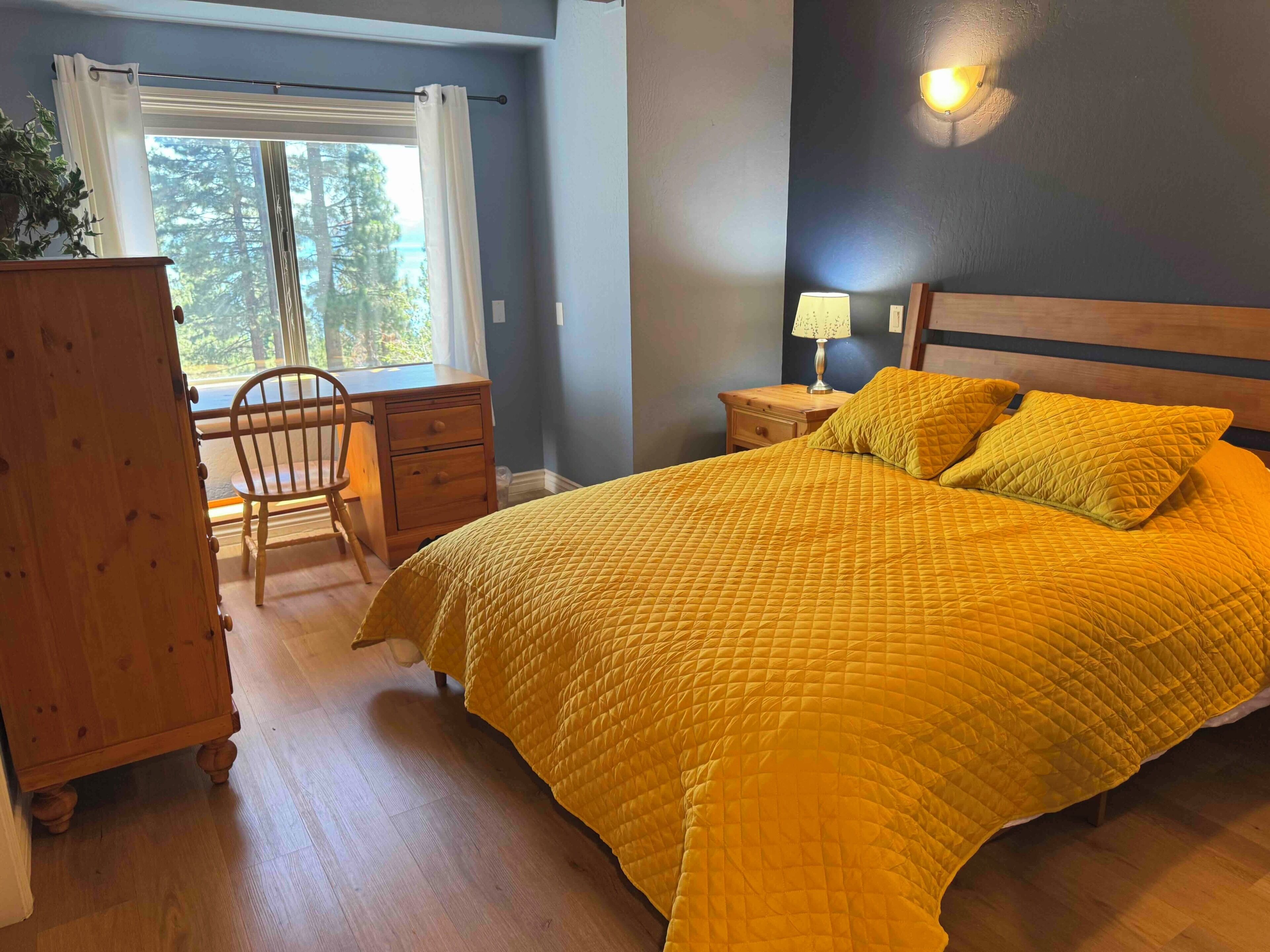 Une chambre à coucher comprenant un lit, un bureau, une chaise et une commode.