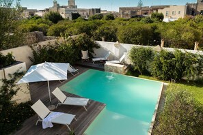 A rectangular swimming pool with a wooden deck and white lounge chairs. - Melissa - Designer apartment in historic building 5 min from Lecce (San Cesario di Lecce)
