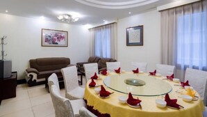 A conference room with a glass table, white chairs, and a brown sofa. - Gongbaofu Hotel (Chongzhou)