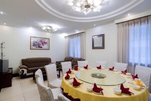 Una sala de conferencias con una mesa de vidrio, sillas blancas y un sofá marrón.