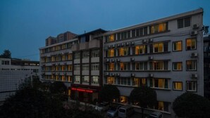A multi-story hotel with a modern architectural design, featuring a series of balconies and a central courtyard. - Gongbaofu Hotel (Chongzhou)