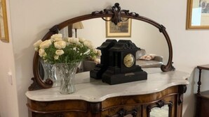 Una consola de madera con un reloj y un florero.
