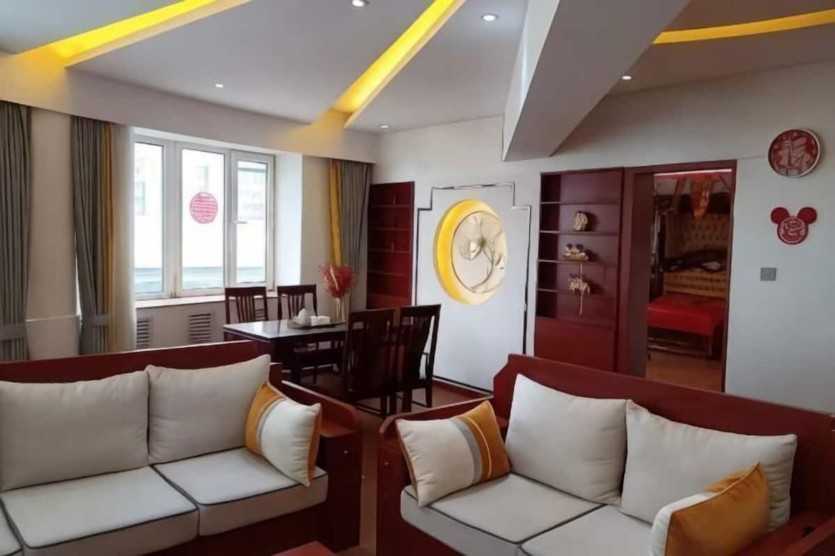 A hotel room with a sofa, dining table, and a bed.
