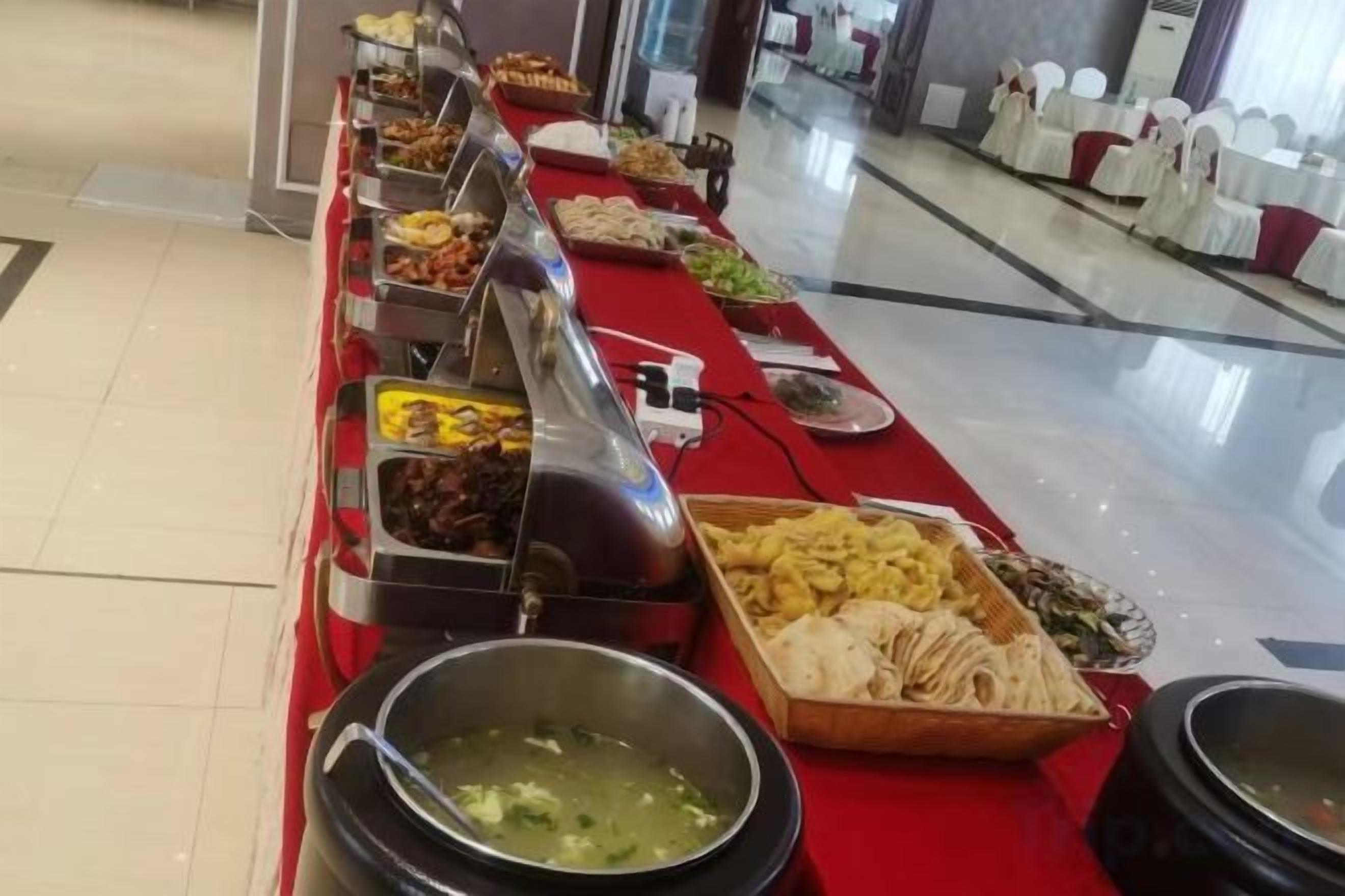 Una mesa de buffet con diferentes alimentos y una barra de servicio.