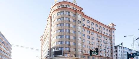 A multi-story hotel with a curved facade, multiple balconies, and a prominent entrance with signage.