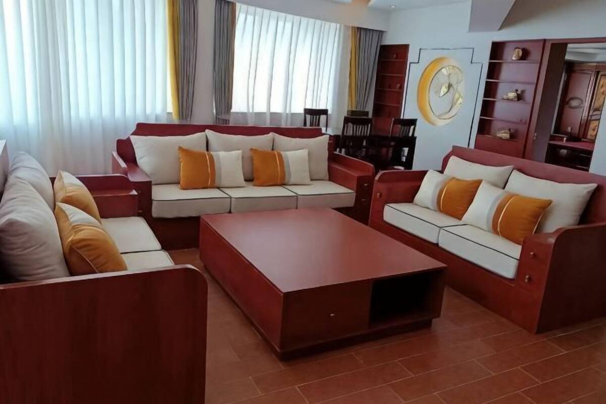 A modern living room with a sectional sofa, a coffee table, and a TV.