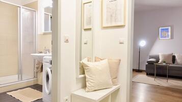 Un baño moderno con lavadora, lavamanos y espejo.