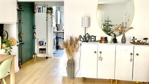 Una sala moderna con un mueble blanco, un espejo redondo y una decoración 'NOEL'.