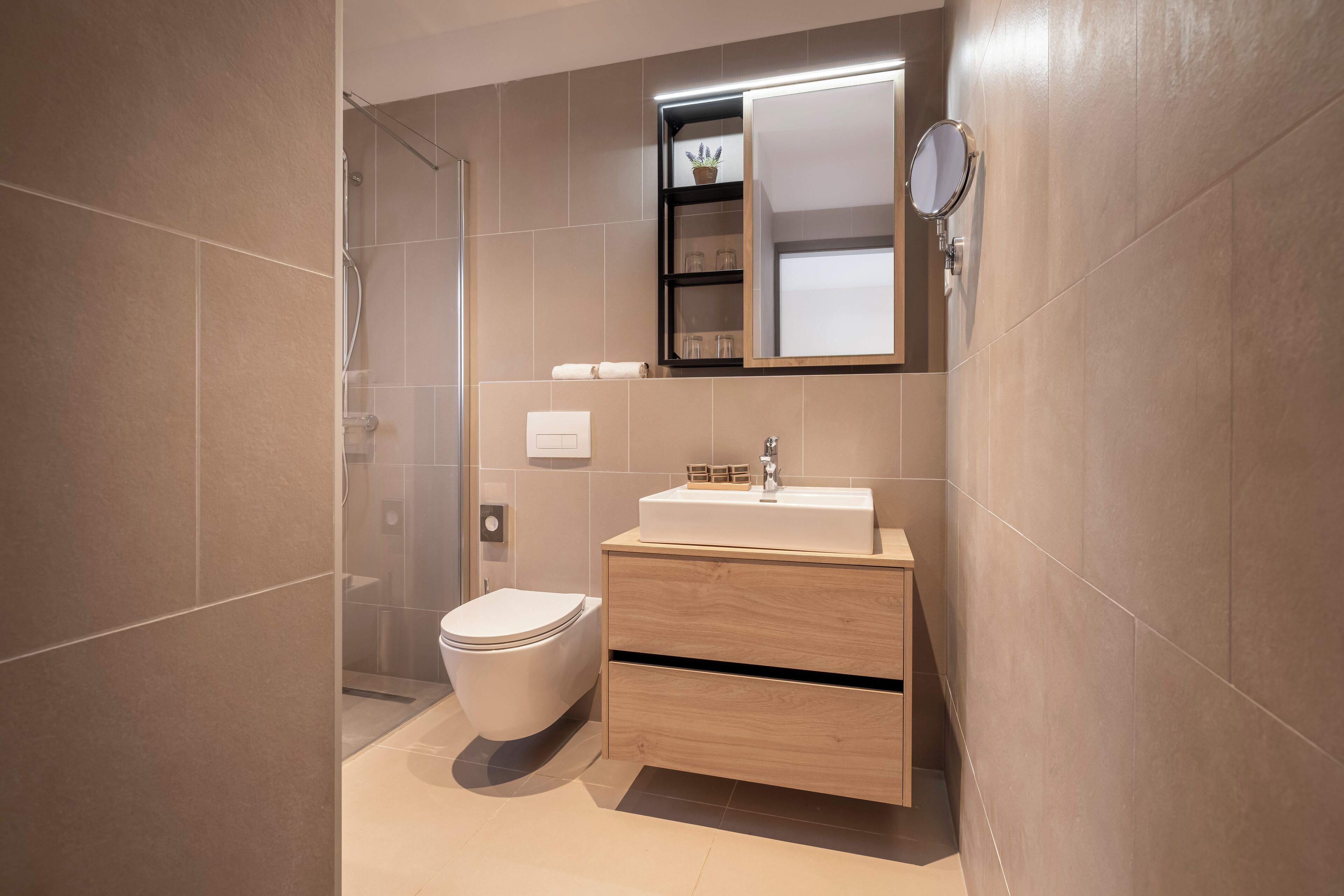 Een moderne badkamer met toilet, wastafel en douche.