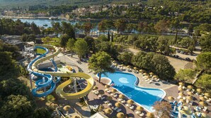 A resort with a water park, a swimming pool, and a view of the surrounding mountains and water.