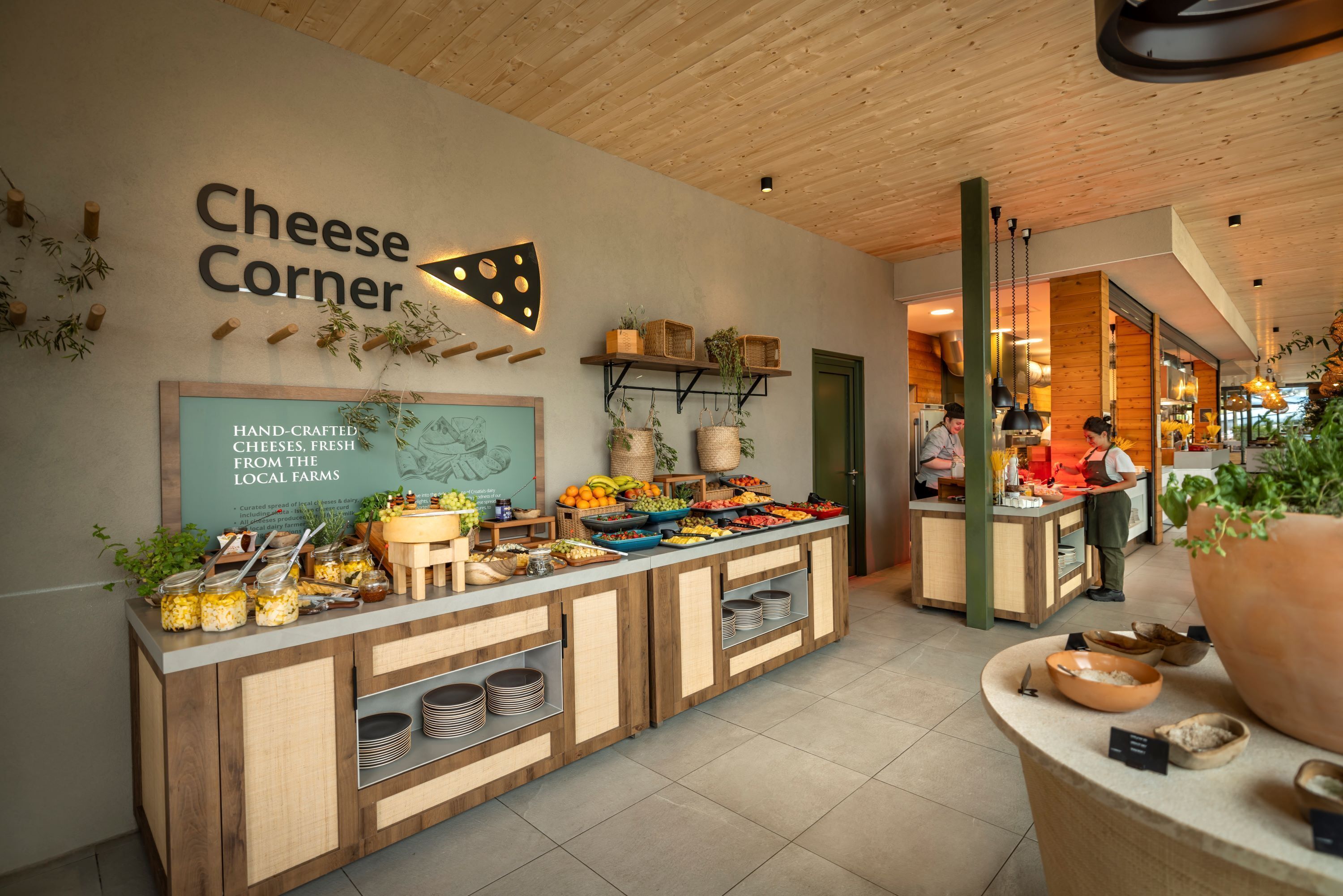 Un espace buffet agrémenté d’un panneau indiquant « Coin des fromages » et où sont présentés des fromages artisanaux.