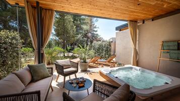 Relax in style with a comfortable seating area, hot tub, and serene views of the surrounding greenery.