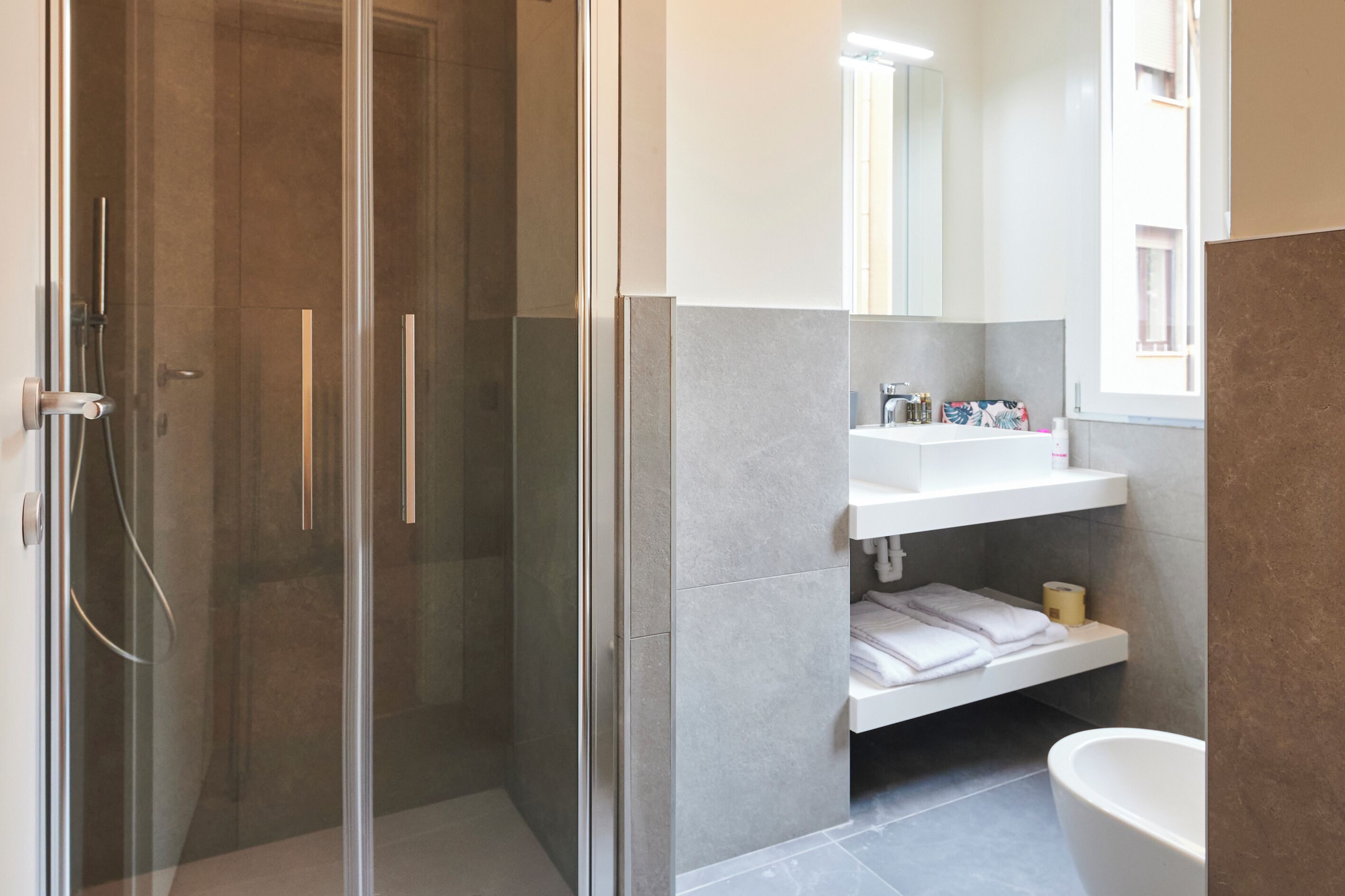 Une salle de bain moderne avec une douche à parois de verre, un lavabo blanc et une grande baignoire.