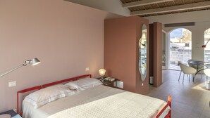 Una camera da letto con un letto, un comodino, una lampada e vista all'esterno.