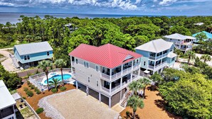 Una propiedad costera con varias construcciones, piscina y vistas al mar.