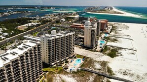 Un hotel costero con varios edificios altos, una playa y un puerto deportivo.