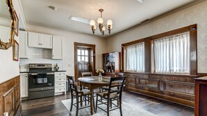 A spacious kitchen with wooden cabinets, a built-in oven, and a dining area with a round table and chairs. - Spacious Carriage House | Private Entrance | Historic & Stylish (Springfield)