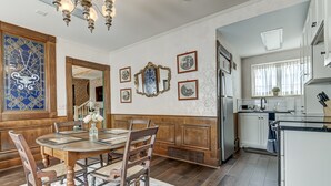 A dining room with a wooden table and chairs, a chandelier, and a large mirror on the wall. - Spacious Carriage House | Private Entrance | Historic & Stylish (Springfield)