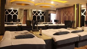 A hotel room with multiple beds, a piano, and a mirror.