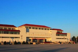 A building with a flat roof, multiple windows, and a prominent entrance. - Anhua Hotel (Wei County)