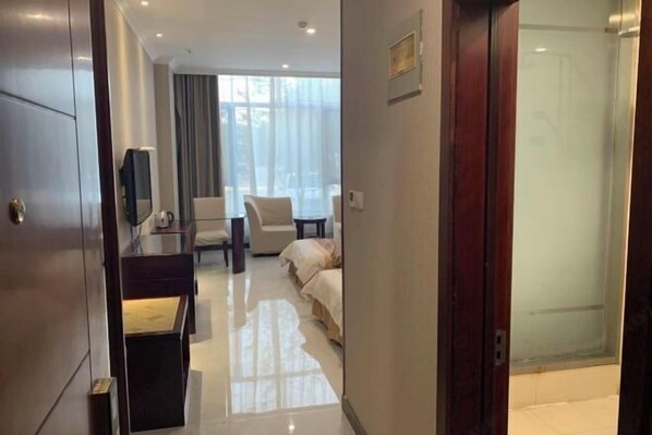 A hotel room with a bed, a desk, a chair, and a TV. - Anhua Hotel (Wei County)