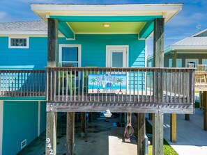 Relax on the spacious balcony with a sign that reads 'FLIP FLOPS & TANK TOPS,' perfect for unwinding.