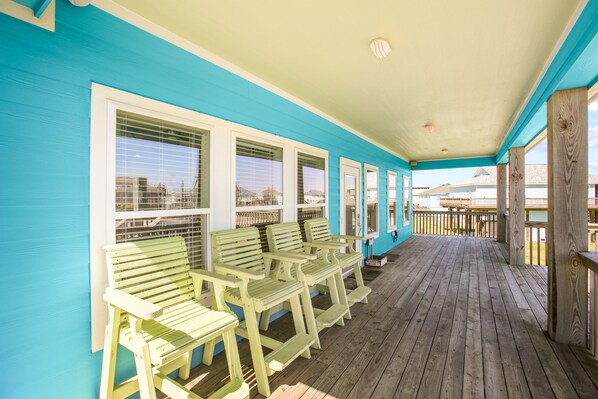 Relax in this serene outdoor seating area with a wooden deck floor and comfortable benches along the wall.