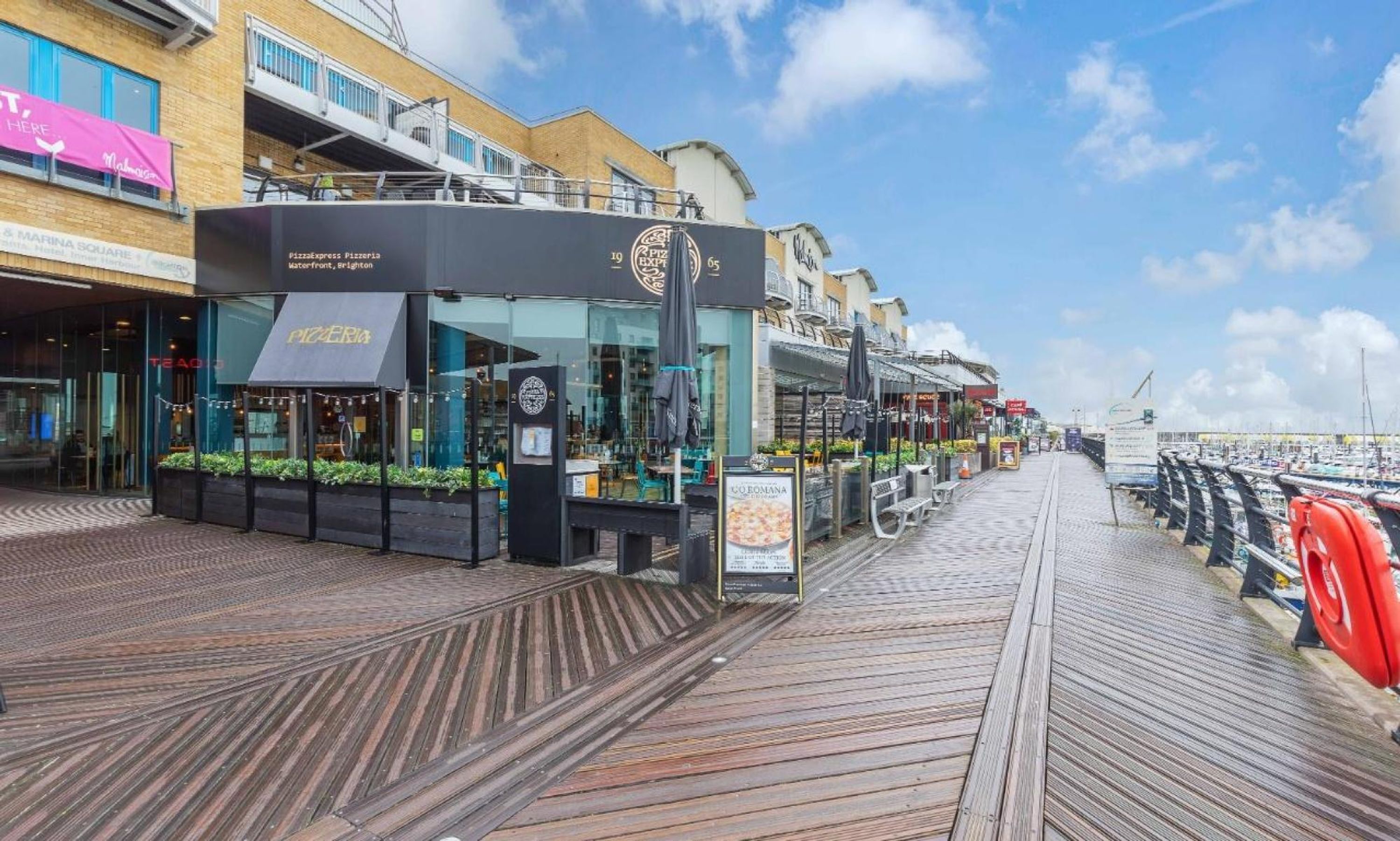A waterfront boardwalk with restaurants and shops.