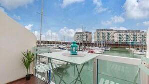 A balcony with a view of a marina, a potted plant, and a teal lantern. - On the Water 2 -waterside Studio With Terrace Overlooking the Harbour (Brighton)