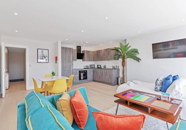 Un appartement moderne comprenant une cuisine, un coin repas et un salon.