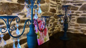 Three blue candle holders with crystal decorations against a stone wall background.
