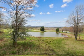 A serene landscape with a pond, trees, and a distant mountain range. - Comfort and beautiful views combine to create GREAT! Come perch at Crows Nest (Canaan Valley)