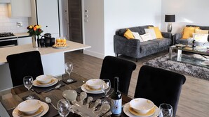 Una sala de estar moderna con un sofá gris, cojines amarillos y una mesa de centro.