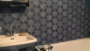 Ein Badezimmer mit Waschbecken, Badewanne und Spiegel.