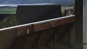 Ein Balkon mit Blick auf einen See, Berge und ein Dorf.
