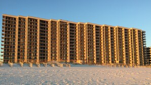Un edificio de gran altura con varios pisos y balcones, rodeado por un paisaje nevado.