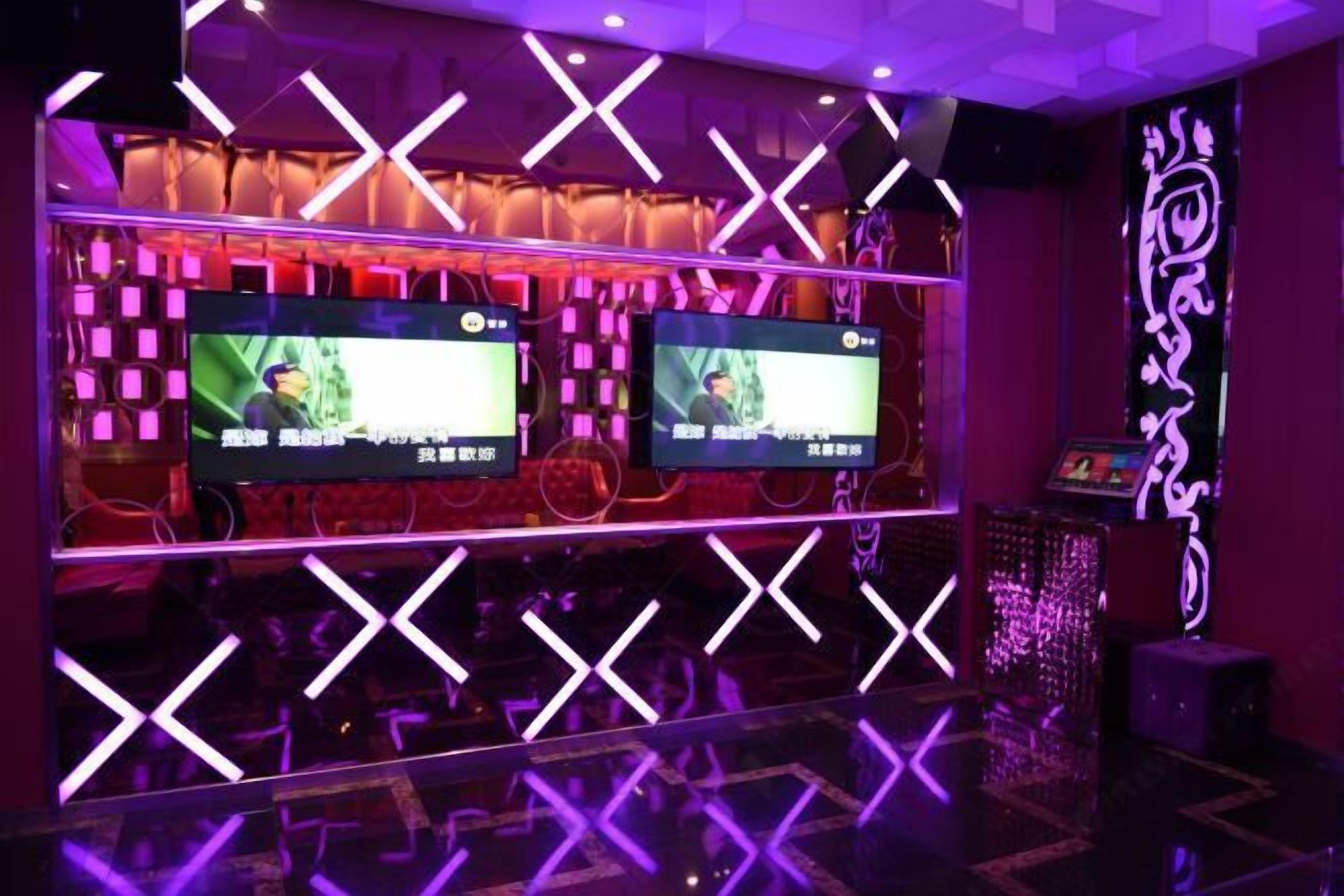 A room with a modern design featuring geometric patterns on the walls and a large screen displaying content.