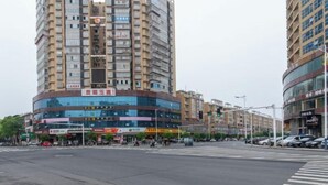 A multi-story building with a ground-level commercial area, including shops and a visible traffic light. - Dongting Hotel (Nan County)