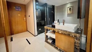A modern bathroom with a marble vanity, a large mirror, and a shower area. - Dongting Hotel (Nan County)