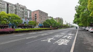 A street with a clear road marking and parked cars on the side.