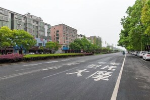 Una calle con señalización vial visible y automóviles estacionados al lado.