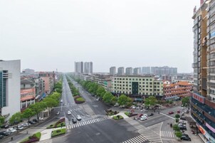 Una calle urbana con edificios, un paso de peatones y automóviles estacionados.