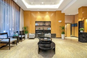 A modern hotel lobby with a seating area, a coffee table, and a bookshelf. - Haoshuimian Hotel (Zhenjiang)