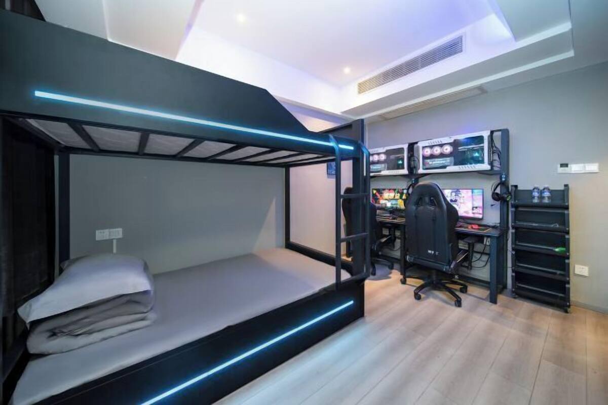 Ein Stockbett mit Schreibtisch und Computerarbeitsplatz im Zimmer.