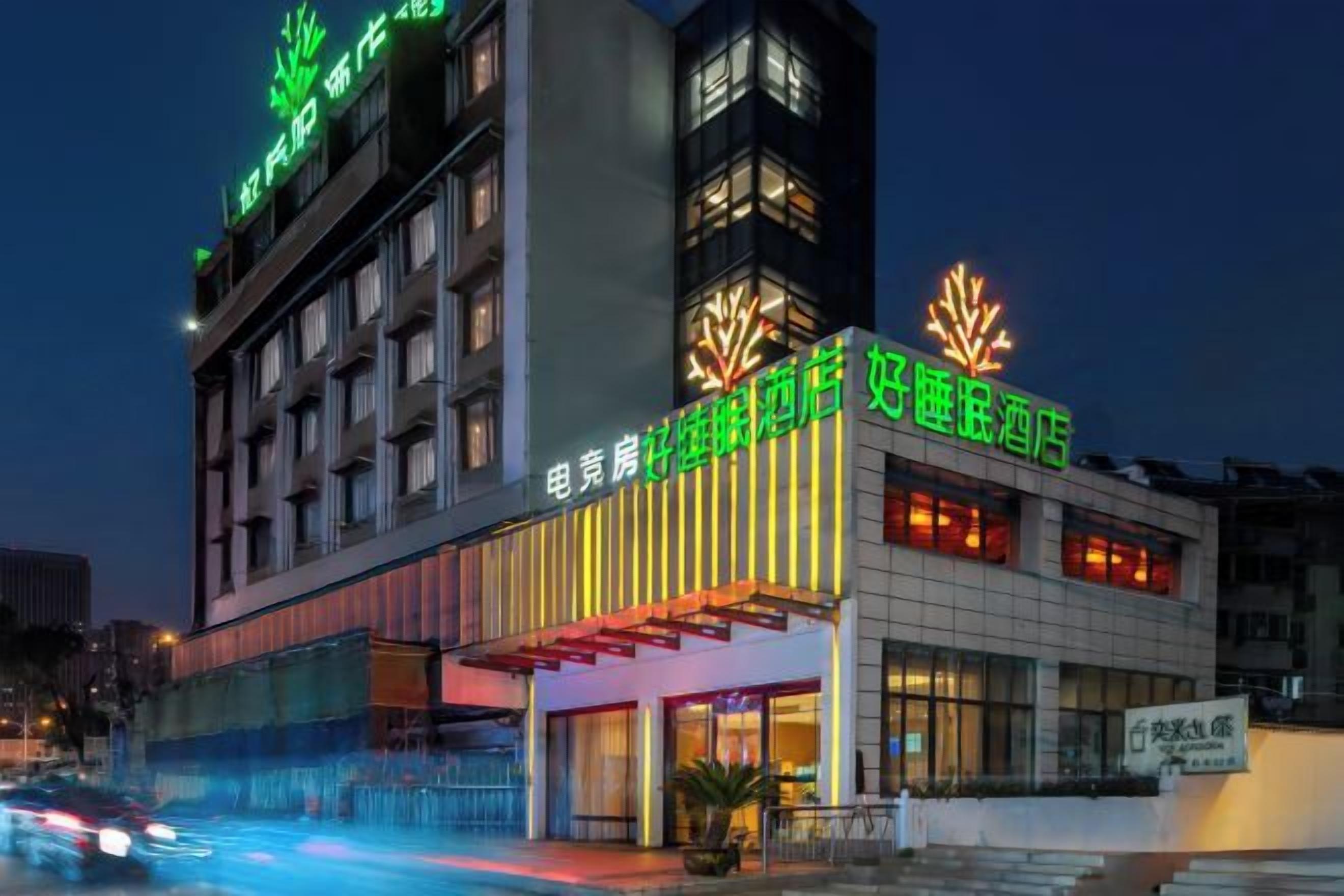 Un hotel amb façana moderna, diversos pisos i cartelleria il·luminada.