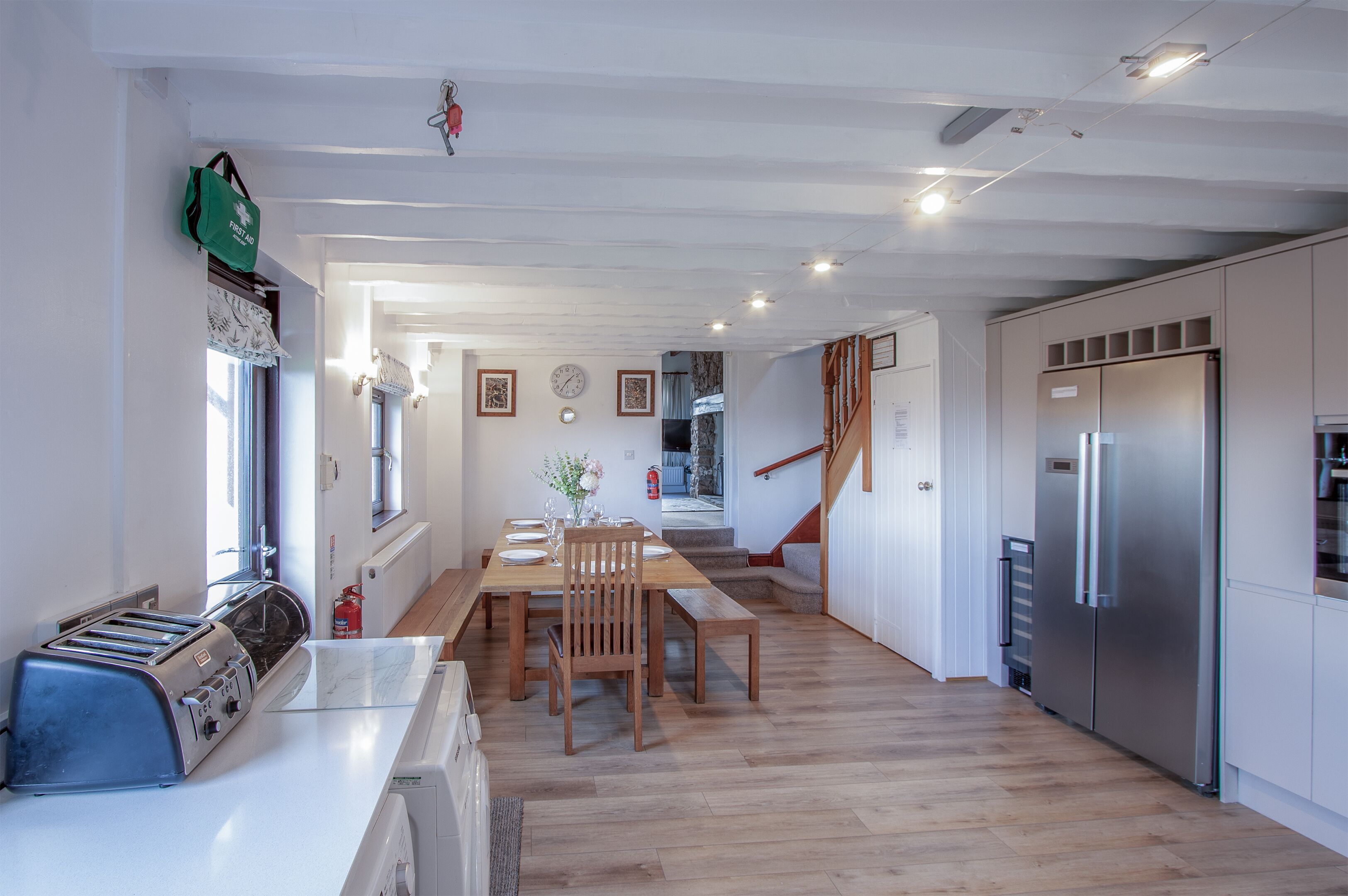 Eine moderne Küche mit Holztisch, einem eingebauten Ofen und einem Edelstahl-Kühlschrank.