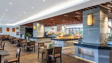 Un restaurante espacioso con una isla central, varias zonas de estar y un diseño de interiores moderno.