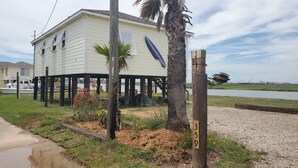 Uma casa com varanda, uma palmeira e uma placa com o número 359.