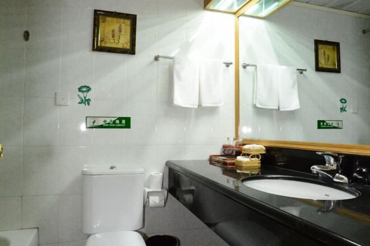 A bathroom with a toilet, sink, and towel rack.