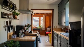 A compact kitchen with a central island, wooden cabinets, and a view into the dining area. - Lakefront  Hot tub. Amazing views. 35 min to Indy (Martinsville)